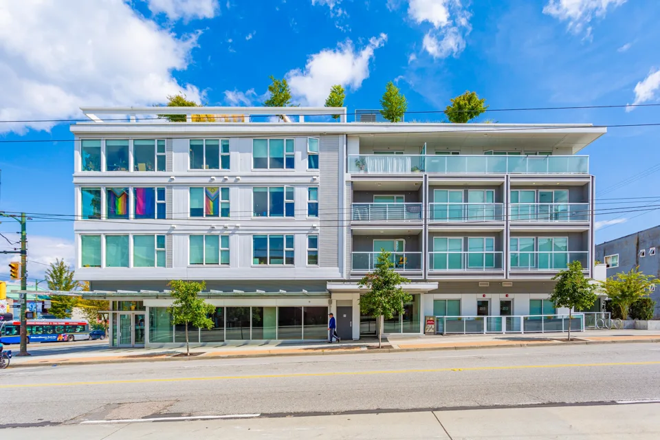 Contemporary apartment building with balconies and ground-floor storefronts