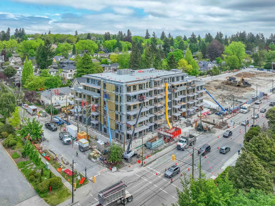 Corner development under construction with surrounding streets and homes