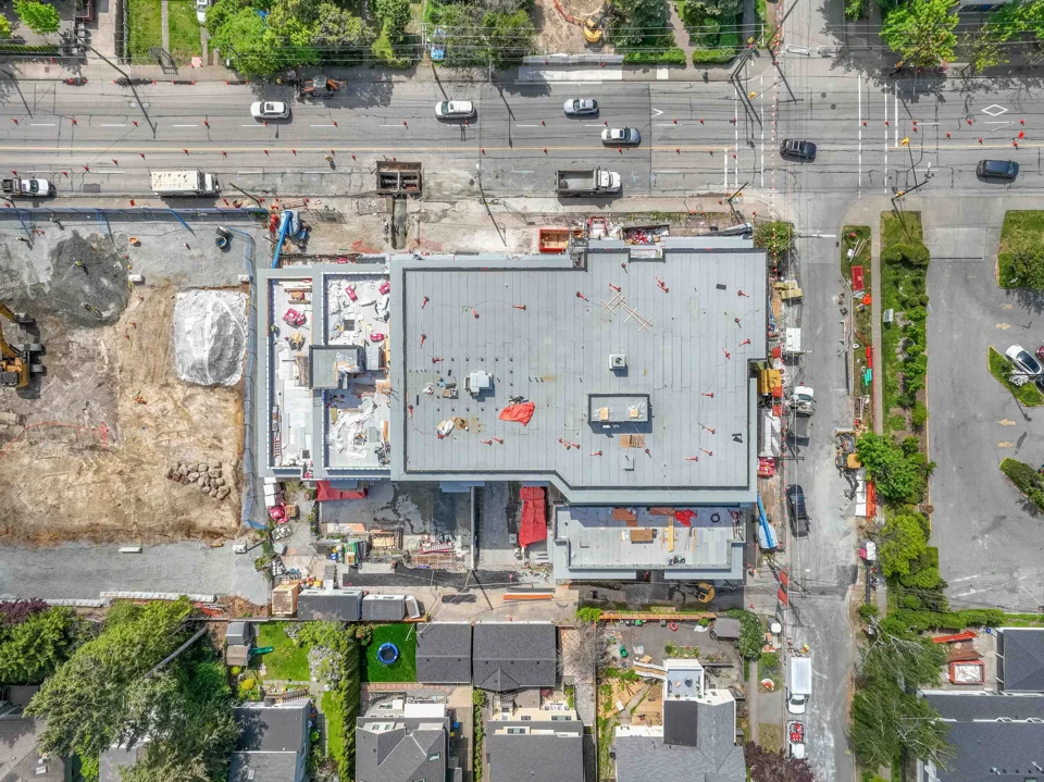 Direct overhead view of a building site, roof and surrounding streets