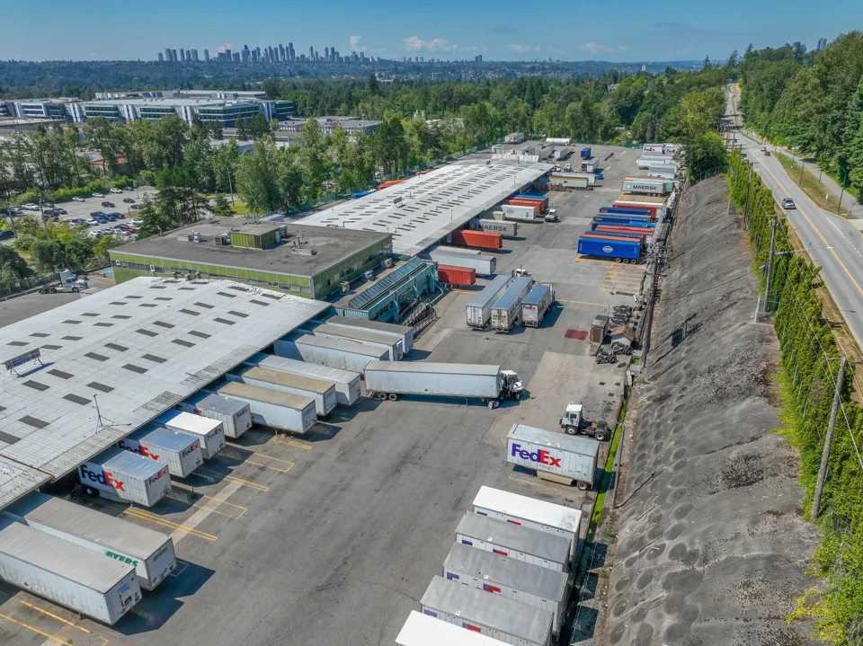 Freight terminal with rows of loading bays and trailers viewed from above