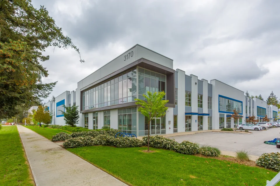 Modern industrial building with a glazed corner entrance and landscaping