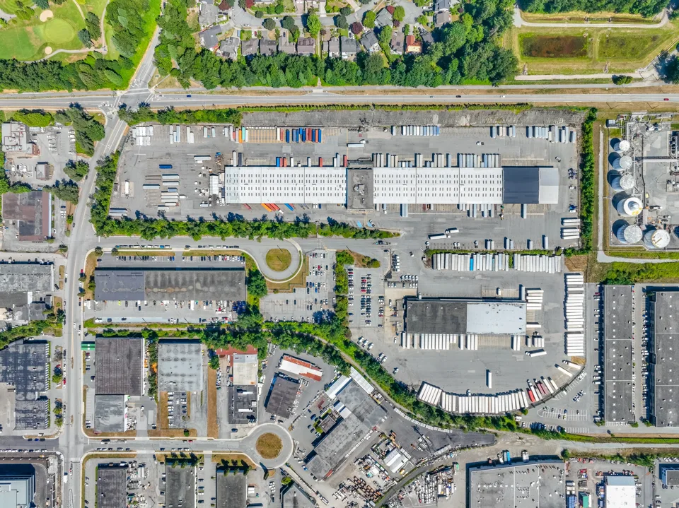 Overhead view of a logistics site with loading yards and road access