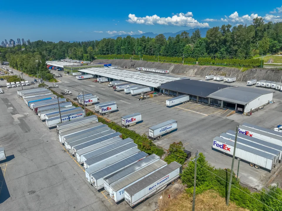 Loading yard with rows of trailers beside a freight warehouse