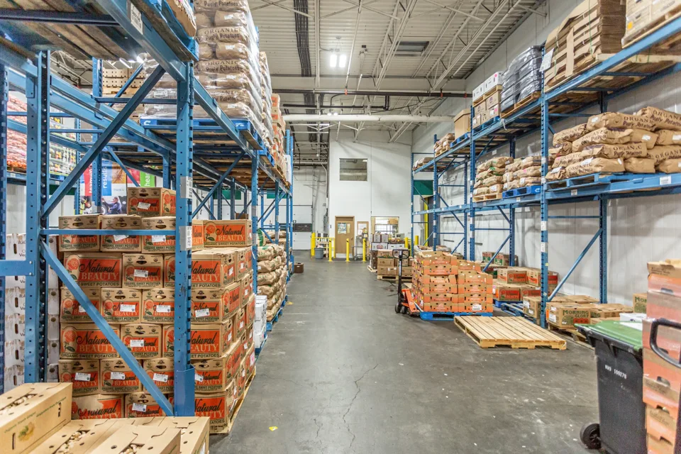 Stocked warehouse aisle with blue racking and pallets