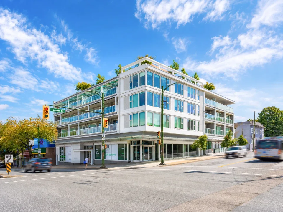 Corner apartment building with balconies and ground-floor shops